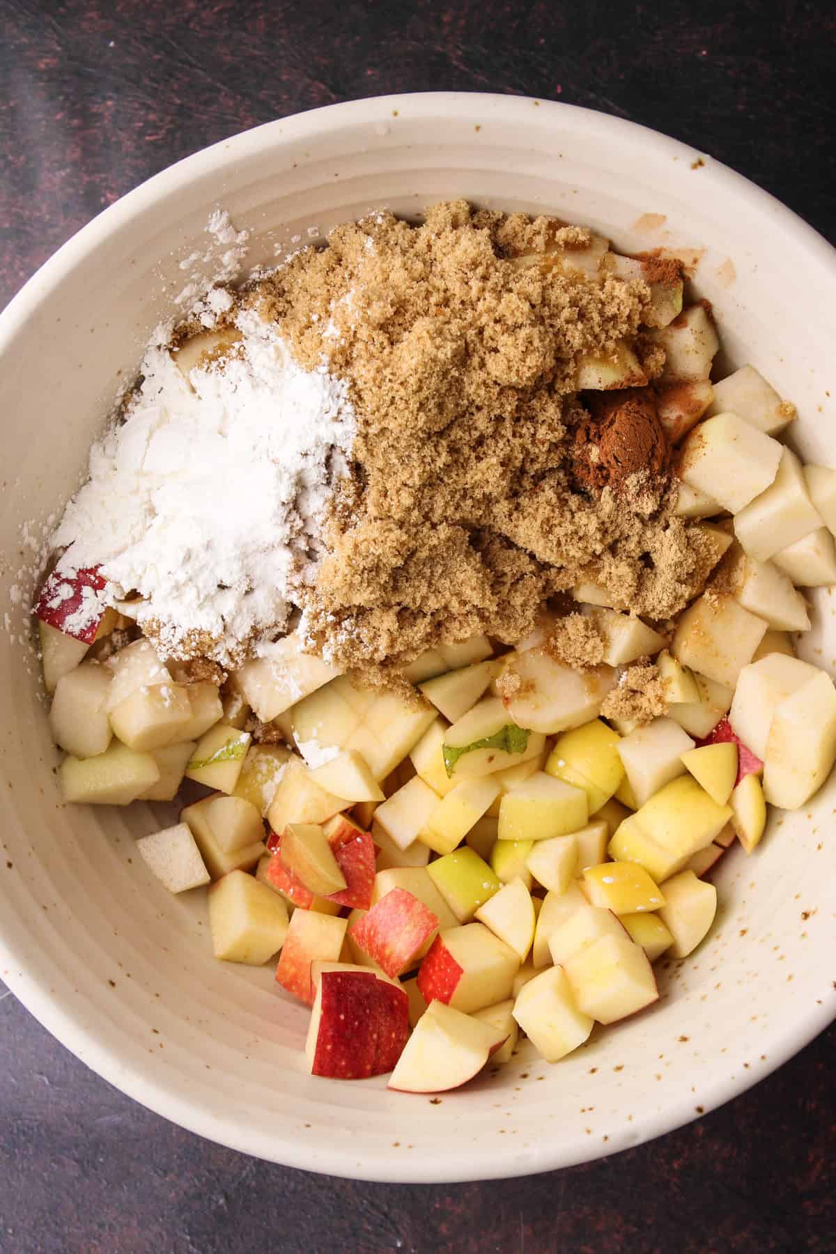 The filling ingredients in a bowl for an apple pear crisp recipe.