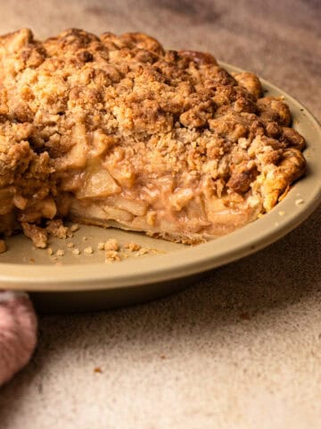A dutch apple pie with a slice removed to reveal the creamy filling.