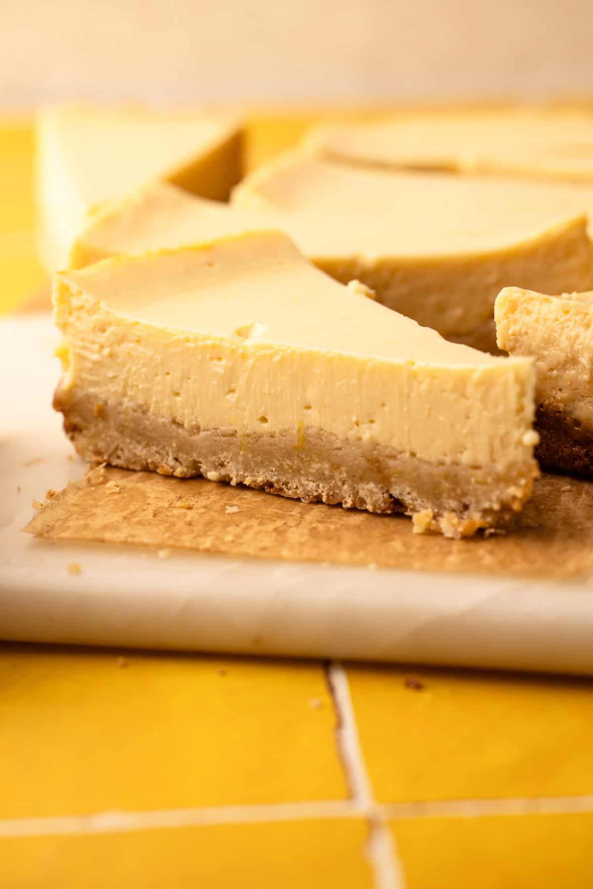 A cut lemon pie bar with a crumbly shortbread crust and a creamy lemon filling.